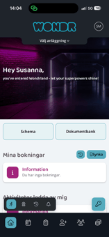En skärmbild av mobilversionen för webbportalen "WONDR". Överst syns statusfältet på en telefon med tiden 14:04 och en 5G-anslutning. Startsidan hälsar användaren med texten ”Hey Susanna,” mot en mörk bakgrundsbild av en träningslokal. Under rubriken finns två stora knappar: ”Schema” och ”Dokumentbank”. Sektionen ”Mina bokningar” visar ett informationsmeddelande om att det inte finns några aktiva bokningar, och intill finns knappar för bokningshistorik och synkronisering. Längst ner finns ett mörkt navigeringsfält med flera ikoner och en separat ljusblå knapp med en nyckelikon till höger.